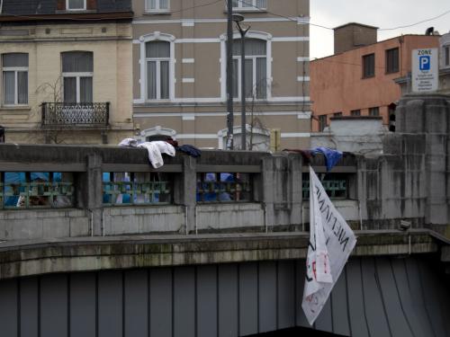 La banderole sur laquelle est écrite "Niemand is illegaal sauf l'état" (Personne n'est illégal sauf l'état) a été à moitié arrachée par le vent, très fort aux abords du Canal.
