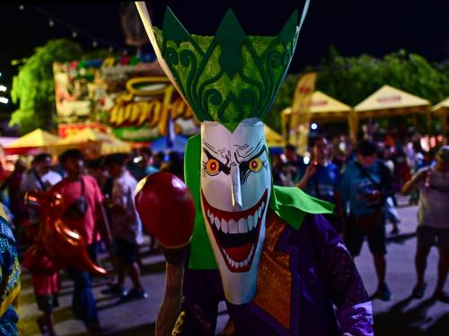 This photo taken on June 23, 2023 shows festival-goers wearing ghost masks and colorful costumes while dancing at night during the annual Phi Ta Khon carnival or ghost festival in Dan Sai district in northeastern Thailands Loei Province. (Photo by MANAN VATSYAYANA / AFP)