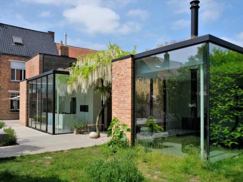 De tuinkamer en de leefruimten worden verbonden door een groene patio.