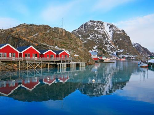 Des maisons typiques se reflètent dans les eaux d’un fjord.