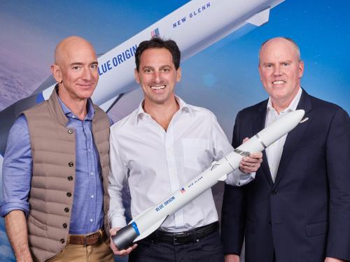 Een schaalmodel van de New Glenn, met links in beeld Blue Origin-baas Jeff Bezos.