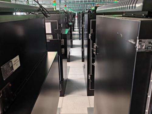 Verspreid over 200 cabinets worden hier om en nabij de 20.000 smartphones simultaan getest.