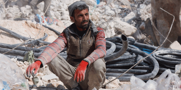 Man zit op puin na ravage aardbeving Harem, Syrië
