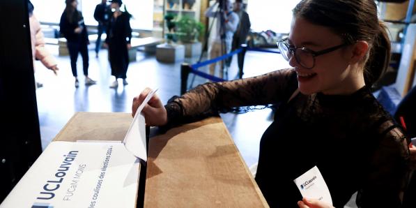 Jeune fille qui place un bulletin de vote dans une urne