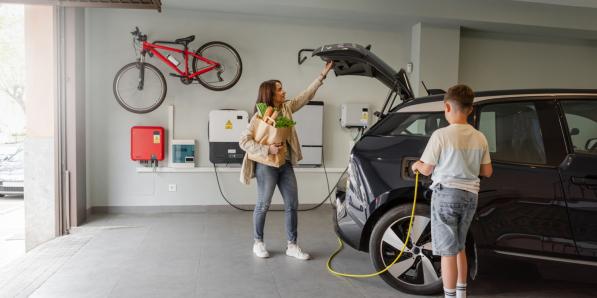 famille chargeant son véhicule électrique à la maison avec une batterie domestique