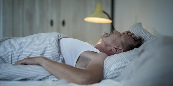 Homme âgé malade (grippe) couché dans son lit