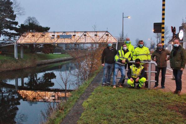 Schepen Wim Janssens (uiterst rechts) met zijn team van de Technische Dienst dat de voorbije dagen overal de kerstverlichting heeft geïnstalleerd, ook aan de voetgangersbrug in Adinkerke.©MYRIAM VAN DEN PUTTE MYRIAM VAN DEN PUTTE