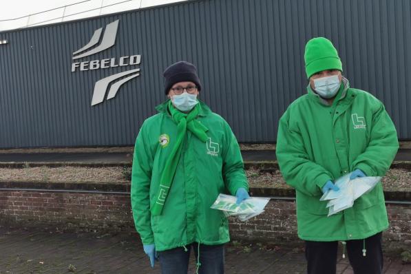 Werknemers Pol Vanbeckevoort en Johan Claerbout die mondmaskers uitdelen.© vadu
