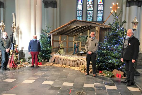 Roger Dekeyser, Walter Deschodt en Gaby Van Huylenbrouck, de bouwers van de duurzame kerststal, met rechts de Kortrijkse deken Geert Morlion.© NOM