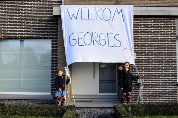 Het gezin van Ilse Vanneste, haar man Bert en dochters Laure (8) en Estée (6) hadden een groot spandoek aan de deur gehangen om het pasgeboren zoontje van Van Aert te begroeten.© TVW