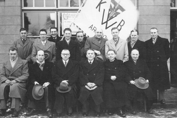 Op de foto uit het archief van februari 1955 herkennen wij onder meer Victor Sagaert, Robert Deven, Camiel Samyn, Abel Cleppe, EH Devogelaere (verbondsproost), Maurice Debruyne, Joseph Devriese, Maurice Depla met de vlag, Victor Verfaillie, Leon Maeseele, Albert Debusschere en Roger Debusschere. (repro JM)© (repro JM)