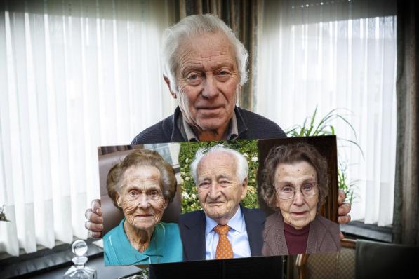Okra-voorzitter Jacques Verhulst, met foto van de drie 100-jarige leden: Madeleine Vangheluwe, Gerard Berteloot en Maria Noppe. (foto JS)©jan_stragier;Jan Stragier Jan Stragier