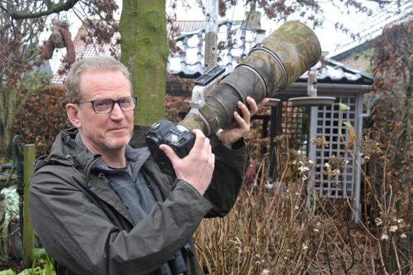 Danny in de tuin met zijn 'kanon'. “Het is ook leuk om je waarnemingen te kunnen delen met andere vogelspotters.”© WK