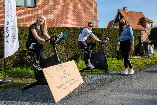 Bart en Petra zitten op de fiets, met Ellen Baar die toekijkt.© Davy Coghe