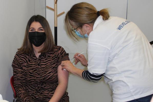 De 23-jarige Saida Qnioun uit Wevelgem kreeg als eerste haar prikje in het vaccinatiecentrum van de Porseleinhallen in Wevelgem.©wilfried Ossieur WO