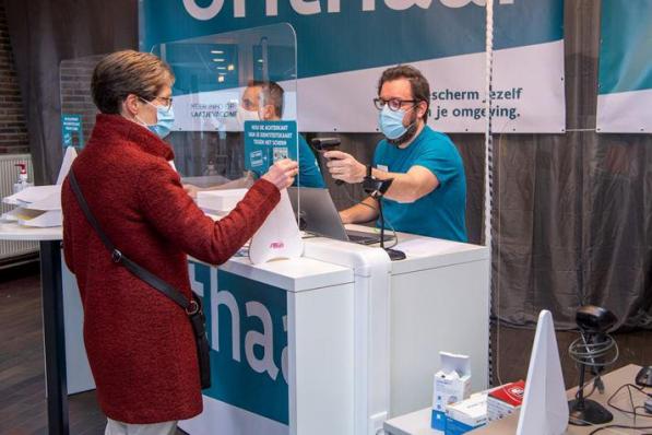 Hilde Coudijzer, die het eerste spuitje in Izegem kreeg, bij haar administratieve check-in.©Frank Meurisse