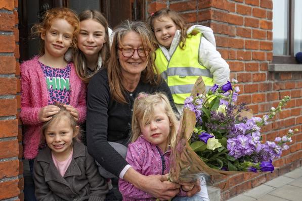 Pleegmoeder Mireille Seys met haar ruiker bloemen in het gezelschap van enkele van haar kinderen. (foto CLL)