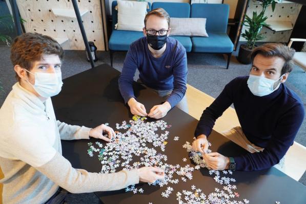 Lars Dombrecht, designer van de puzzel, met Niels Desot en Dimitri Devroe van Puzzle in a Bag: “Creativiteit en een goed product zijn belangrijk, maar uiteindelijk moet je het gewoon durven doen.”© gf