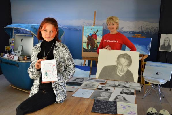 Yeva en Marina bij hun werken. Let op het portret van acteur Peter Van Den Begin en Marina’s man op een beer.© WK