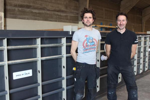 Ondernemers Wim Devreese en Denis Dierickx bij een bijna afgewerkte, kunststoffen badkuip in hun groot atelier aan de Spildoornstraat in Desselgem.© DJW