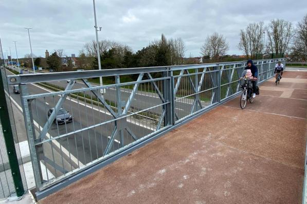 De eerste fietsers rijden over de nieuwe fiets- en voetgangersbrug over de A10 snelweg aan de Konterdam.© Peter Maenhoudt