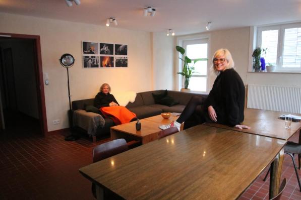 Patrick Smagghe maakt het zich gemakkelijk, terwijl Eline Adam lachend toekijkt in de nieuwe leefruimte van de vernieuwde artiestenresidentie.© ACK