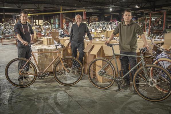 Centaal staat pa Jan Oosterlinck, links zoon Tom met een fiets met verkoperd frame, rechts zoon Peter met het frame dat al tot kopergroen is geoxideerd.©Wouter Meeus