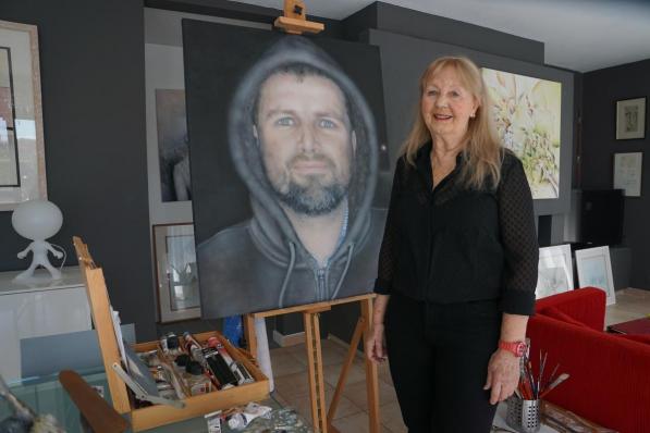 Nelly Paenen met het portret van zoon Jan, die ze omwille van corona maandenlang niet kon zien. Nelly schilderde het portret op basis van een foto. (foto MM)
