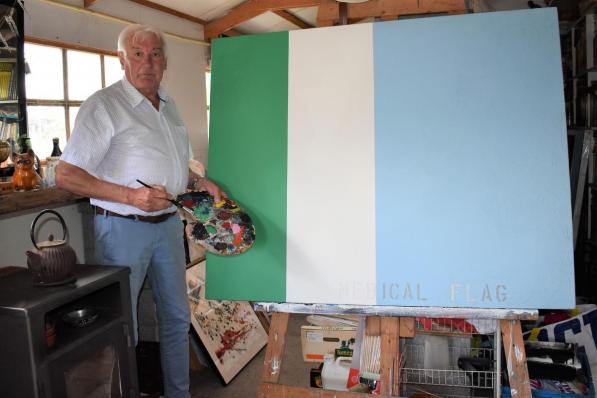 Kunstenaar Marc Desmet in zijn atelier met het schilderwerk waarvan hij graag een ‘Medical Flag’ gemaakt zou zien.©TOM VAN HOUTTE foto TVW