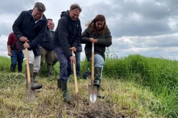 Wim Destoop, Bart Vangansbeke en Minister Demir steken de spade in de grond om de Blankaart te vernatten.© Elise Demaeght