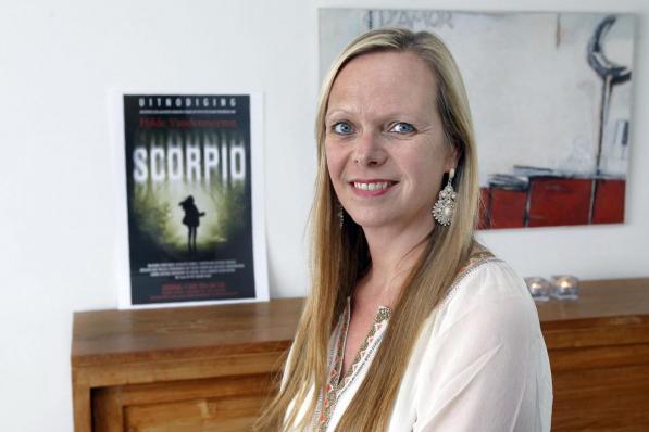 Hilde Vandermeeren bij de kaft van haar boek Scorpio, dat in het Engels vertaald wordt en door een bekende filmproducent geselecteerd werd.©Johan Sabbe