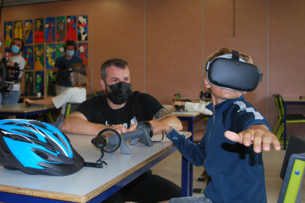Onderzoeker en expert virtual reality-leren Carl Boel kijkt toe hoe een van de kinderen oefent met de VR-bril.© PDC