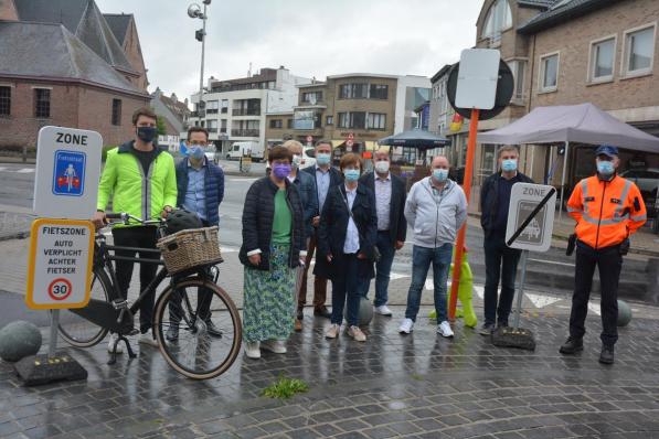 Het college van burgemeester en schepenen bij de nieuwe verkeersborden die worden geplaatst om de fietszone aan te duiden© JC