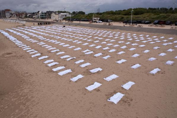 Op het strand van Zeebrugge lagen donderdagmorgen 621 menselijke contouren onder een wit laken. Een actie van Vluchtelingenwerk Vlaanderen om de vluchtelingenproblematiek weer onder de aandacht te brengen.© GF
