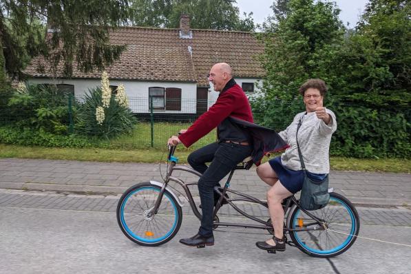 Directeur Karel Scherpereel haalde juf Veerle op met een tandem en samen fietsten ze met heel veel bliklawaai naar school.© PDC