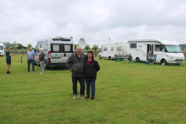 Paul Schapdryver en Nancy Degruyter op hun camperterrein. Op de achtergrond zie je enkele campers staan en gasten die daar van hun vakantie genieten. (foto ACK)©type=