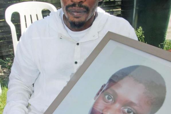 Samuna Barboza met een foto van zijn zoon. Elie werd nog gereanimeerd maar overleed na 20 dagen coma.© Geert Vanhessche
