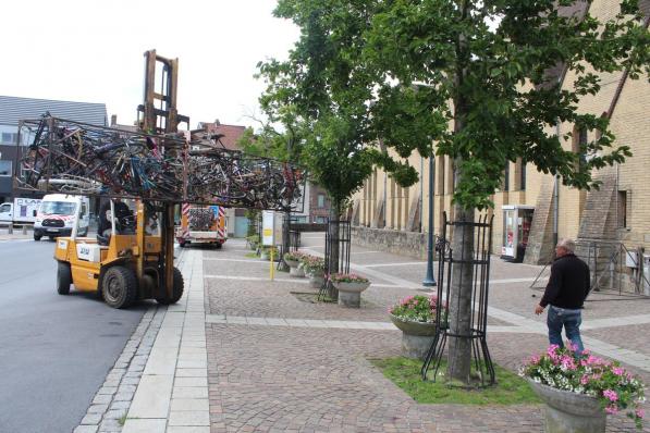 De werknemers van de gemeente zetten het kruis voor de wielertentoonstelling 'Koers is religie' op zijn plaats.© Noor Vanhessche