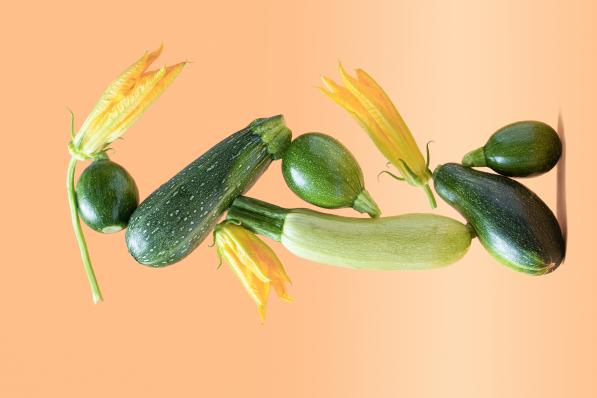 Balance with green zucchini vegetables on beige background. Healthy food and life balance concept.