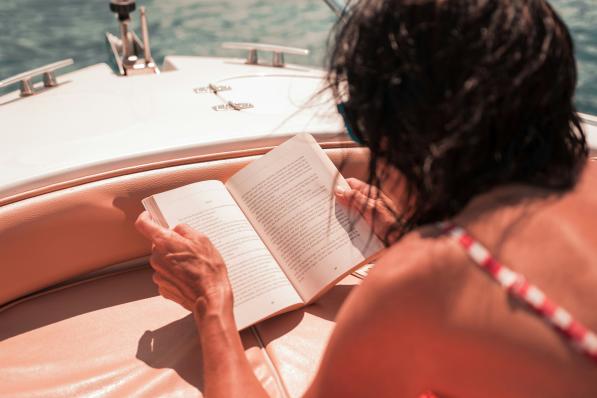 Vrouw leest boek op strand