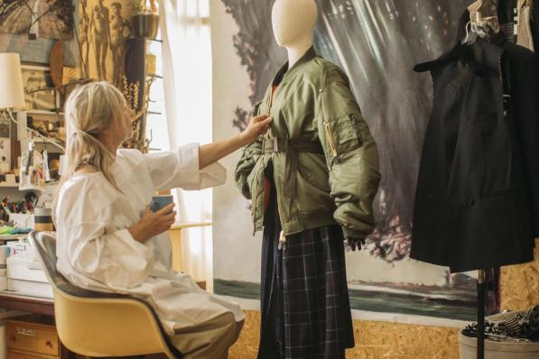 Marina Yee dans son atelier anversois face à une veste (‘Customized Bomber’) et une jupe (‘Black Jack’) de sa collection hiver.