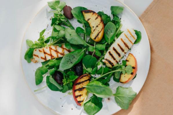 Salade van gegrilde perzik, basilicum, halloumi en zwarte olijven