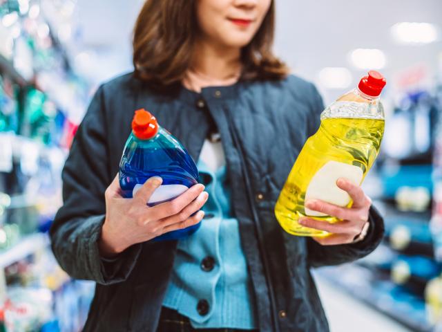Een vrouw die de prijs van producten vergelijkt in de winkel. Kortingen tips.