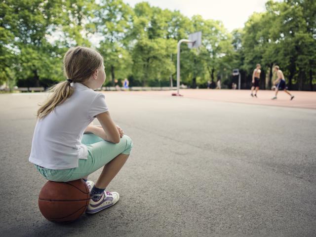 Petite fille seule dans la cour de récré