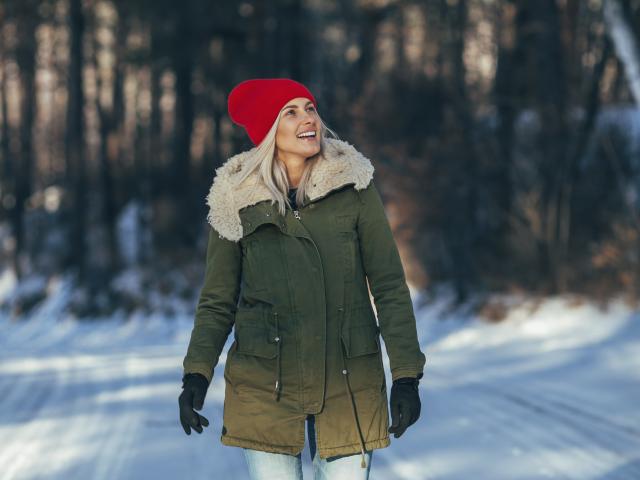 Femme en balade en hiver avec un bonnet rouge