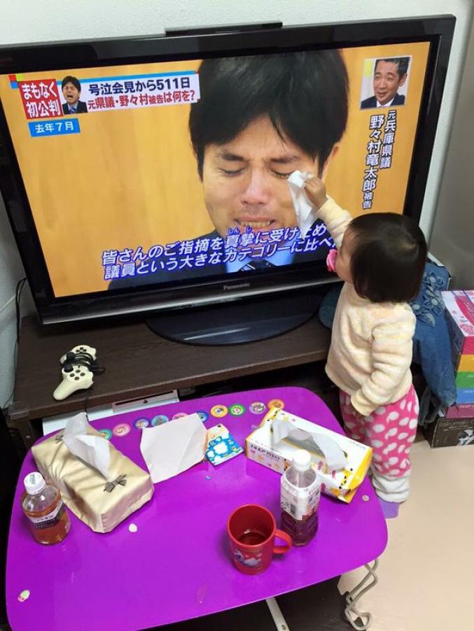 Une petite fille essaie de réconforter un homme qui pleurs à la tv