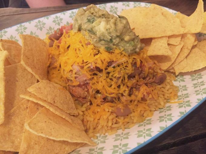 Le plat composé: nachos avec riz au poulet, haricot et sauce salsa
