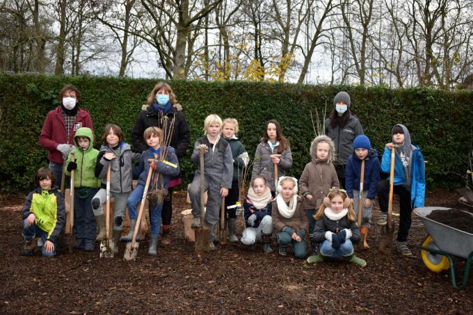 De leerlingen van klas 4 poseren op de ruimte waar bessenstruiken komen, samen met tuinbouwmeester Marnix Desimpel, directrice Barbara Decramer en leerkracht Maaike Monkerhey.© EG