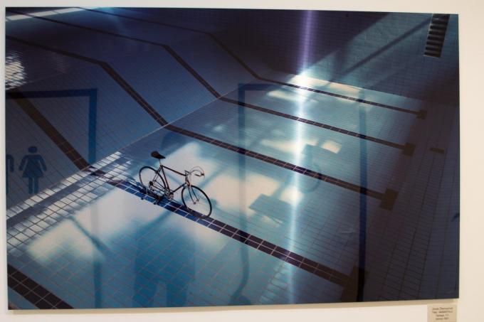 In het sas richting zwembad hangt een foto van de Wevelgemse fotograaf Joost Demuynck, een koersfiets in een leeg zwembad.© foto SLW