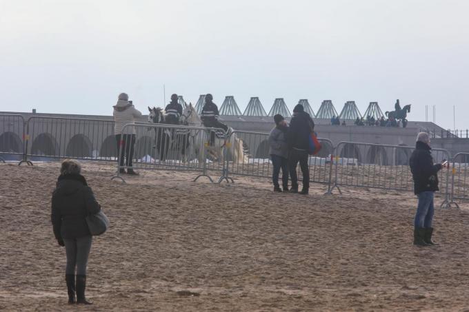 Hier en daar probeert iemand langs de nadarhekkens een glimp op te vangen van de schimmen in de verte, terwijl de politie te paard de wacht houdt.©Peter MAENHOUDT